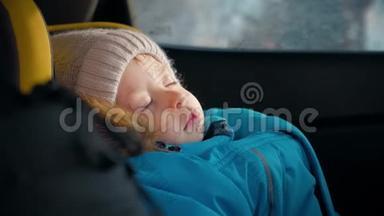 幼儿男孩在汽车上睡在<strong>儿童安全座椅</strong>上。